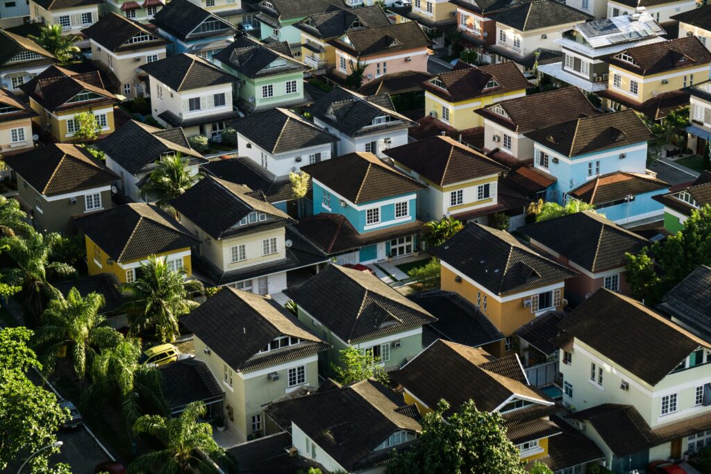 Aerial view of a colorful, dense residential suburb showcasing diverse housing architecture, illustrating the impact of CRE market strategies on urban development.
