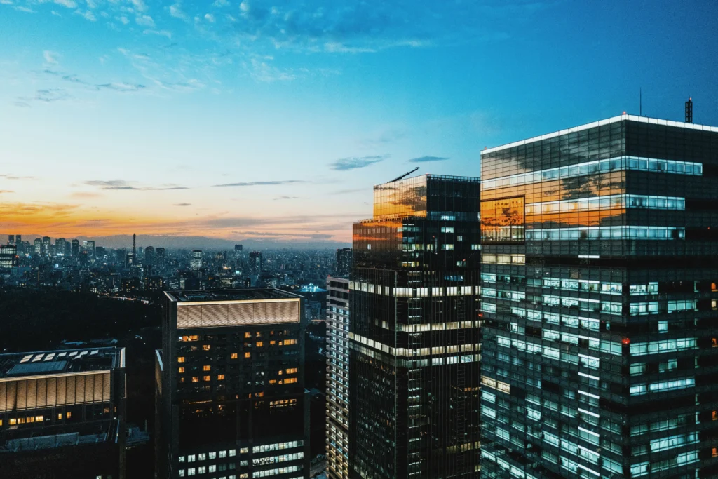 Cityscape at sunset with illuminated buildings, representing opportunities in digital marketing for real estate investors.