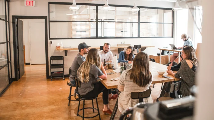 Group of professionals meeting in a collaborative workspace, discussing strategies for capital raising for energy projects.