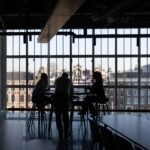 Business team meeting in modern office space with city view — building a capital strategy discussion.