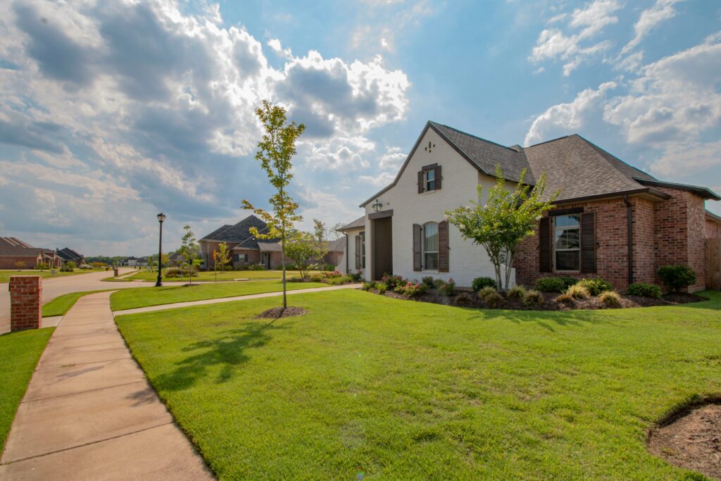 A beautiful suburban home with a green lawn and sidewalk, representing the potential for attractive real estate acquisitions, including those found through the benefits of off market deals.